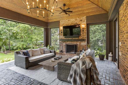 Screened in porch with a wall mounted TV surrounded by sconce lights