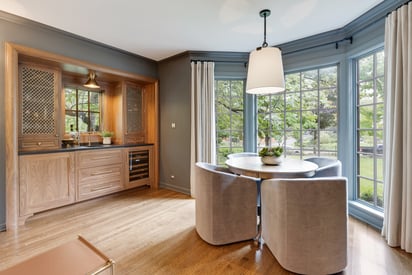 Sitting room/sun room with a few aesthetic chairs and a mini dry bar