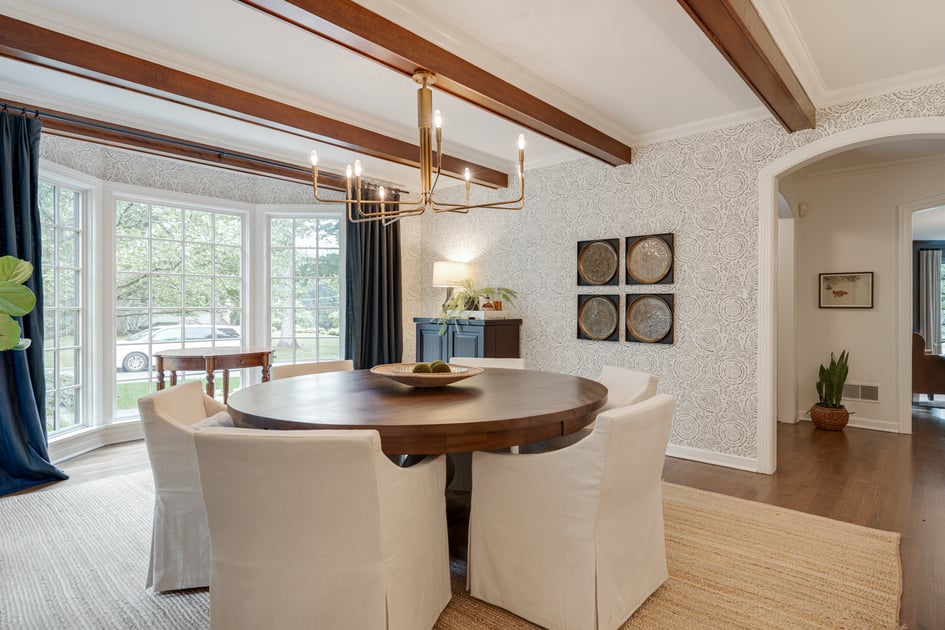 Luxurious and contemporary dining room with four chairs placed around a round table filled with natural light