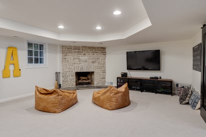 Basement entertainment area with bean bag chairs and a fireplace
