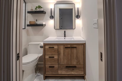 Another full guest bathroom with a single vanity, hard white light, and a walk-in shower over to the left