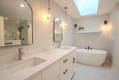 Bathroom with a pure white aesthetic, stand alone tub, and a skylight