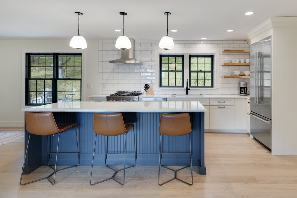 A Kitchen with wooden floor, a marble cooking countertop and marble dinning table with wooden dinning stools underneath