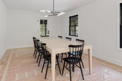 Off angle of a dining room table with a modern statement chandelier