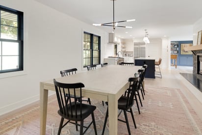 Dining room with a more industrial and rough rectangular dining table with lots of black chairs surrounding it