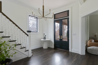 Front door foyer with a simple chandelier and staircase in the background