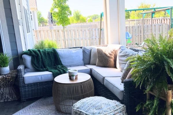 Outdoor furniture set on a porch with a fenced in backyard