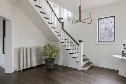 Single turn stair case with a white and brown banister railing