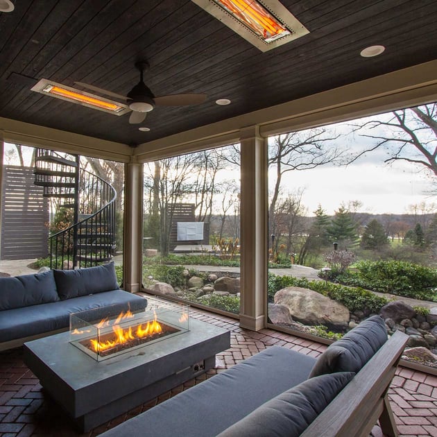 Screened in porch with a stunning view, surrounded by couches and a gas firepit