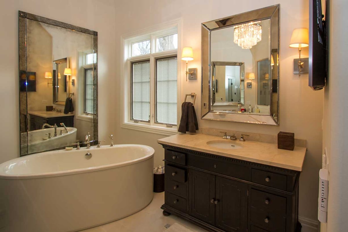 Wide shot of luxury bathroom suite with standalone tub and marble vanities