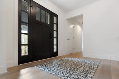 Grand front entrance to a home with a large black door and a foyer