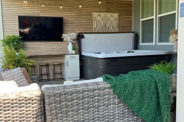 Hot tub tucked into the backyard enclosed porch