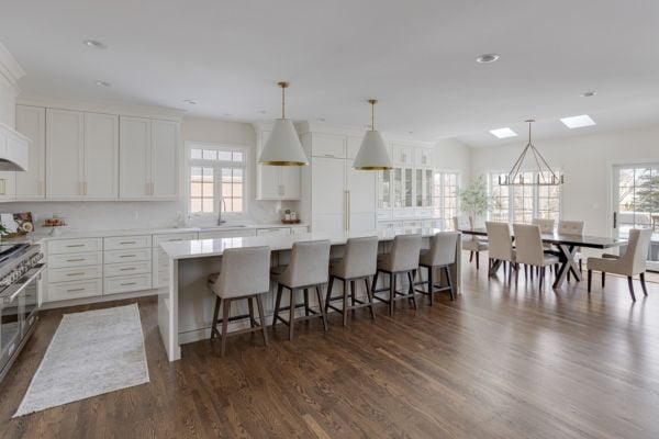 Wide angle shot of a kitchen remodel with a long island, dining area, and luxury vinyl tile flooring