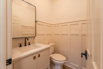 Guest bathroom with trim lining the walls and a single vanity