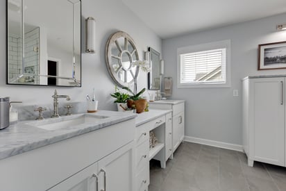 Luxurious and elegant bathroom with 3 mirrors on the wall to the left and a shoulder height window in the back for natural light