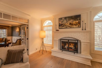 living room fireplace surrounded by furniture and showcasing hardwood floor