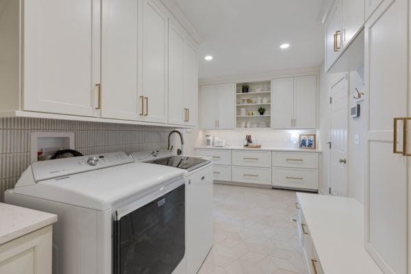 Enhanced laundry room with updated fixtures, matching white appliances, and gold handle fixtures
