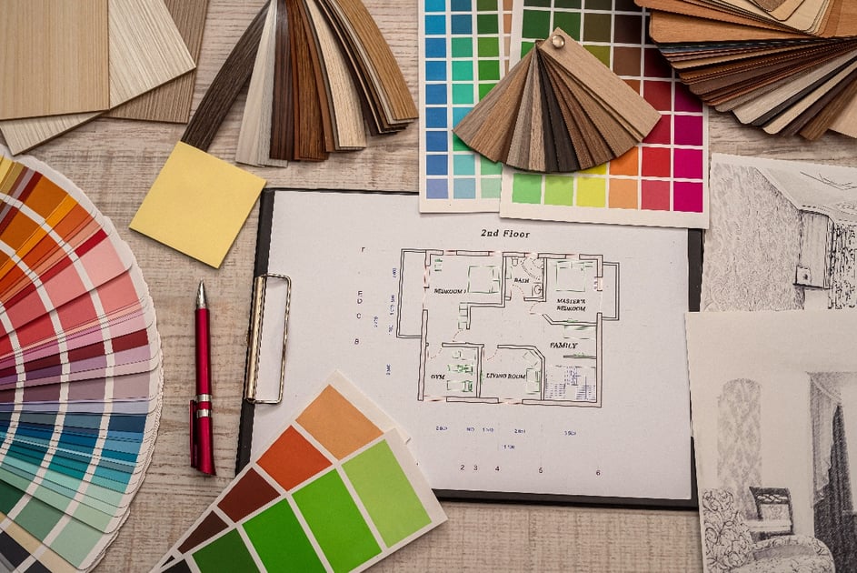 A set of color samples spread out on a table as a designer plans how to color the second floor of a home based on floorplans