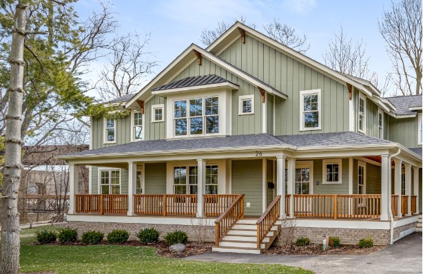 Exterior shot of green house with wooden railings