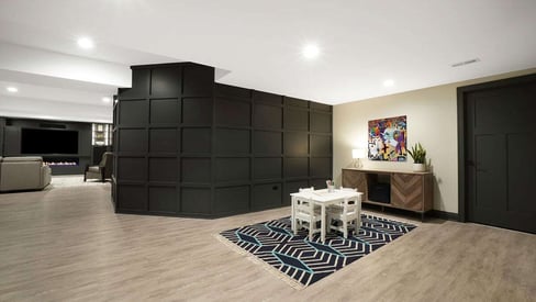 Spacious basement remodel with black walls and luxury vinyl plank flooring