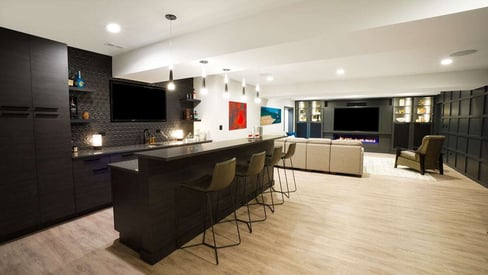 Basement full back and kitchen with pendant lights and a black, modern aesthetic