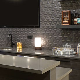 Close up of a candle lit on top of a wet bar in the basement of a luxury home