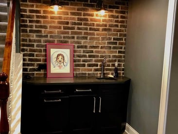 Basement table with a brick wall behind it and a photo sitting on the top of the table