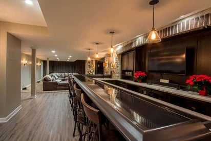 Wet bar with 7 chairs, pendant lights above the table, and red flowers on the counter behind the bar