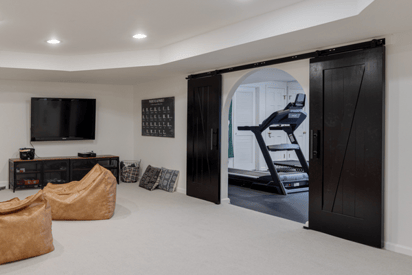 black sliding bar doors in a basement that reveal a home gym