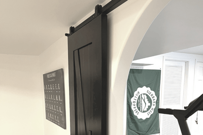 Close up photo of a sliding barn door with black fixtures