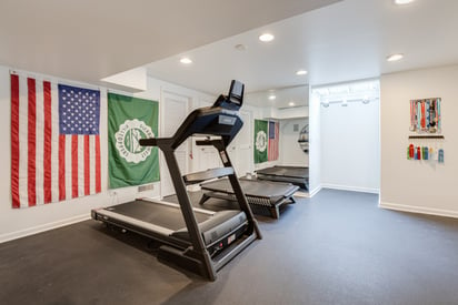 Home gym with a treadmill and lots of can lighting to illuminate the space