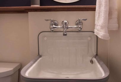 Half bathroom sink in the basement with a wall mounted basin