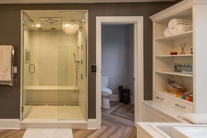 Walk in shower with a separate space for the toilet in a master suite bathroom