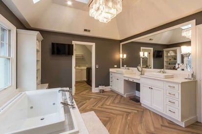 Luxurious bathroom with a large countertop that has a double vanity with a large single panel mirror