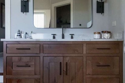 Close up front angle of a wooden bathroom counter with lots of drawers and cabinets on the front