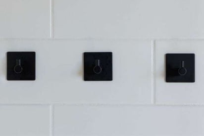 3 shower jets and handles mounted on the while tile wall