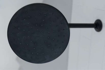 Underside view of a matte black shower head that is not running water