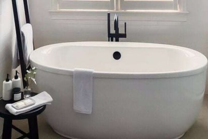 Stand alone, white, porcelain bath tub with modern black fixtures