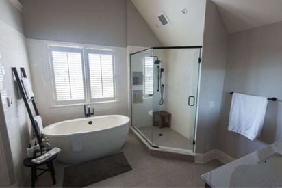 Luxurious, elegant, and modern bathroom with a corner shower, freestanding tub, and high cathedral ceilings