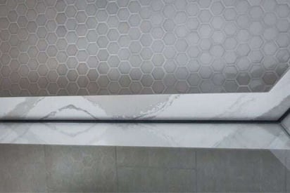 Shower door frame and trim with small hexagonal tile flooring