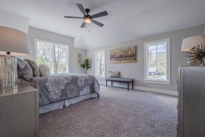 Master bedroom with a calm and neutral color palette and lots of windows for natural light