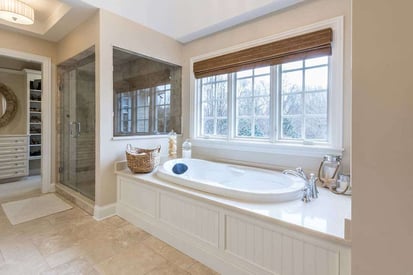 Built in bathtub in a elegant pure white master bathroom suite