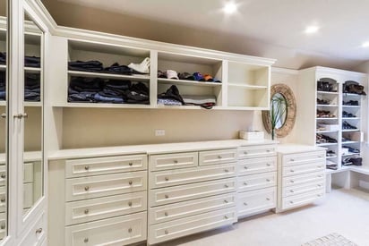 Walk in closet with loads of storage space, drawers, and cubbies with clothes and shoes