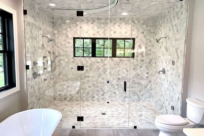 Large double walk-in shower with two shower heads, three windows for light, can lighting, and a curtain mechanism on the ceiling