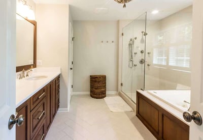 brown cabinetry in a bathroom with white walls and white quartz countertops