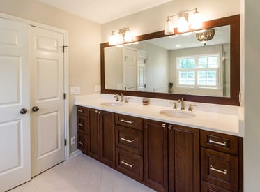 Double vanity bathroom counter with one large mirror that stretches the length of the countertop with two sinks