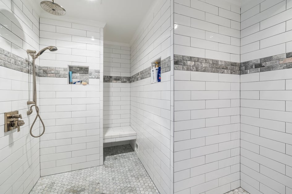 A bathroom bench cut deep into a bathroom wall with two shower recesses