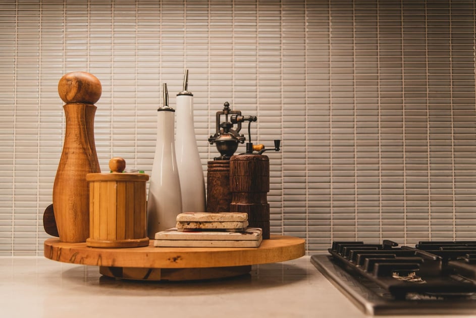 A wooden lazy susan saddled with small containers of cooking ingredients