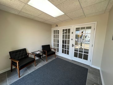 Front vestibule to a business with white glass pane doors