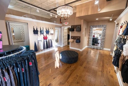 Rounder of clothing in the middle of a store with hardwood flooring